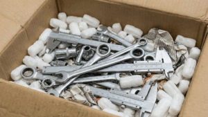 Caja de cartón con herramientas apiladas, embaladas incorrectamente.